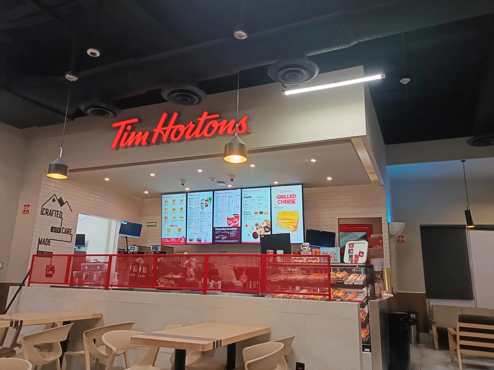 Tim Hortons store entrance in Mexico with illuminated brand sign and digital menu boards