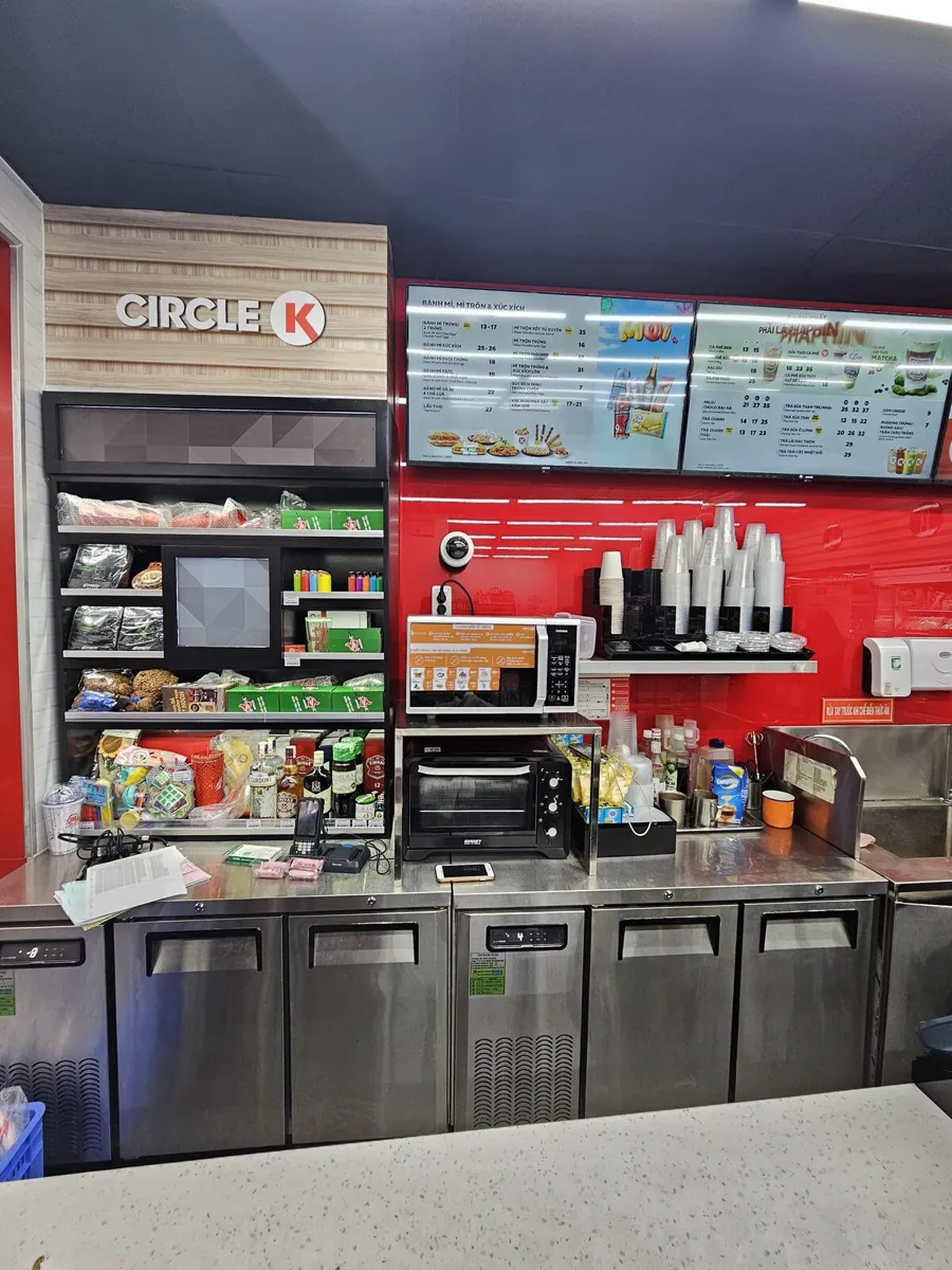 Circle K food counter in Vietnam with two digital menu boards on a red wall