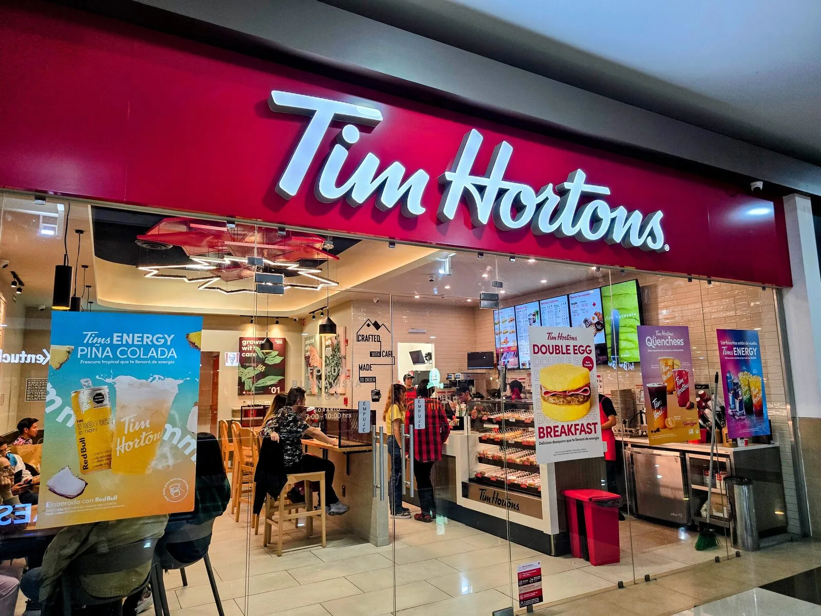 Tim Hortons restaurant interior in Mexico with branded signage and promotional screens