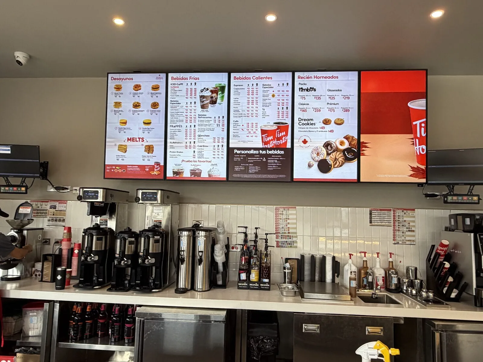 Row of Tim Hortons digital menu boards above the coffee station in Mexico