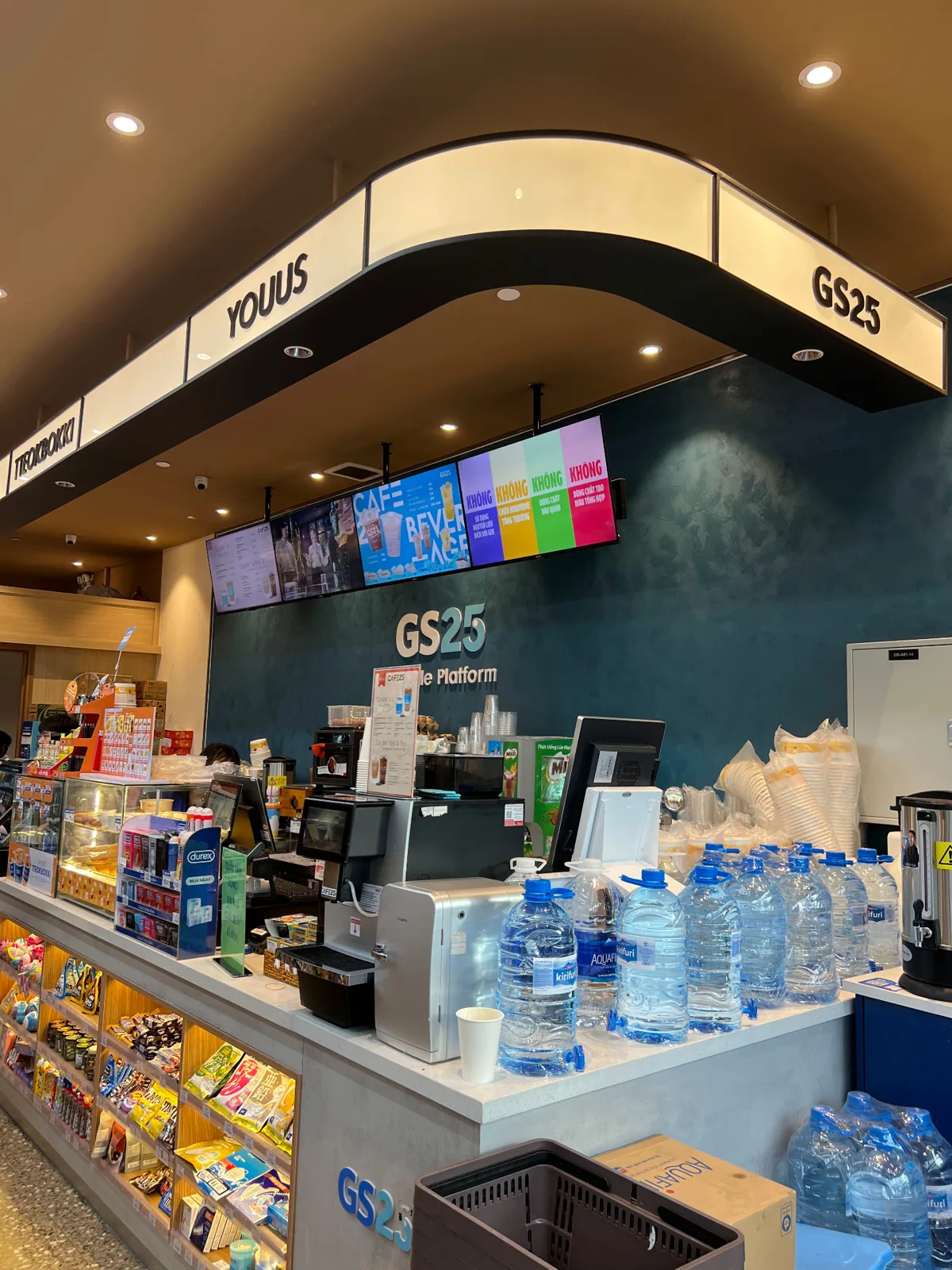GS25 Cafe25 counter in Vietnam with a row of digital menu screens above it