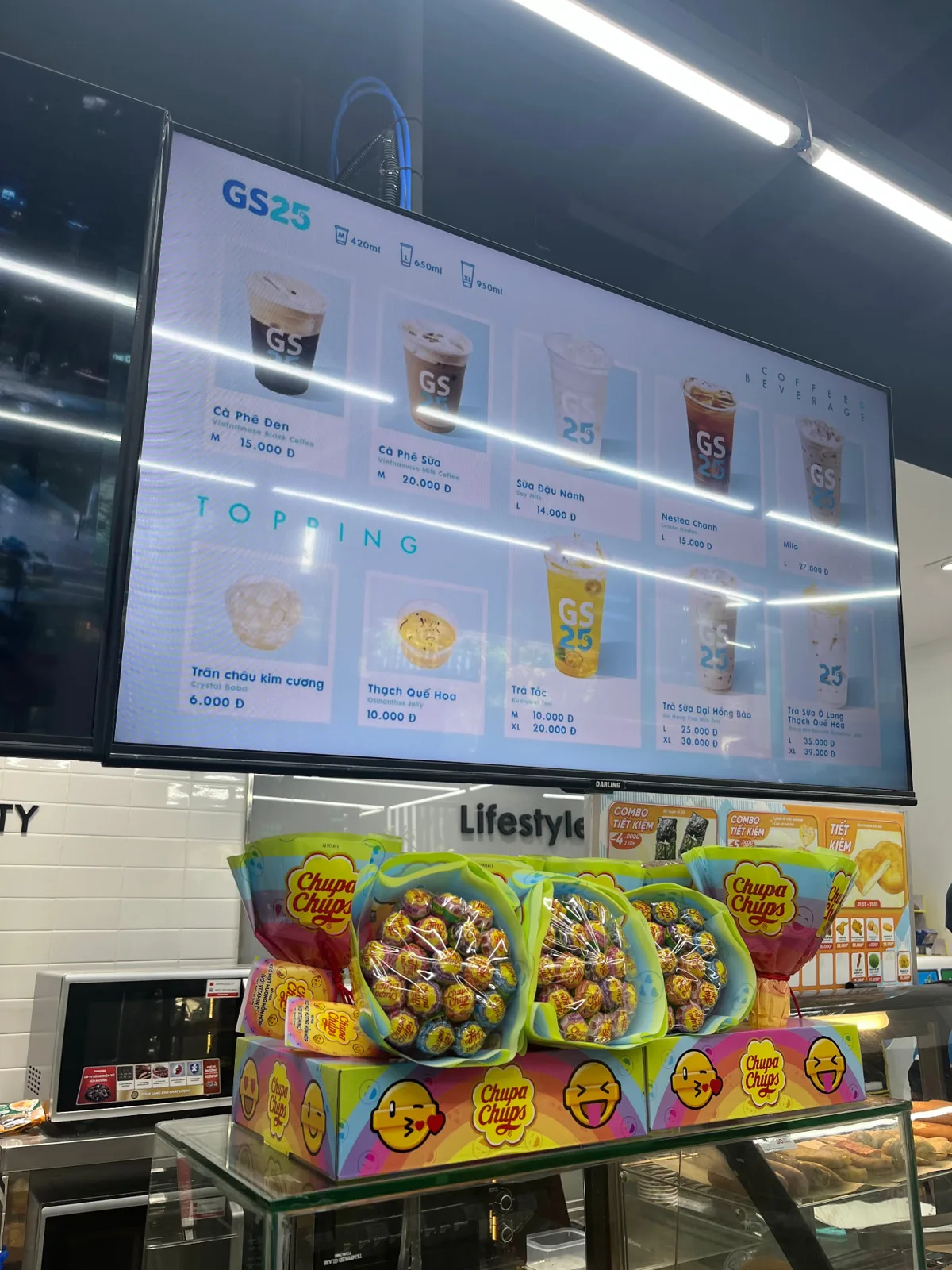 Close-up of a GS25 digital menu board showing coffee, beverages and toppings with prices