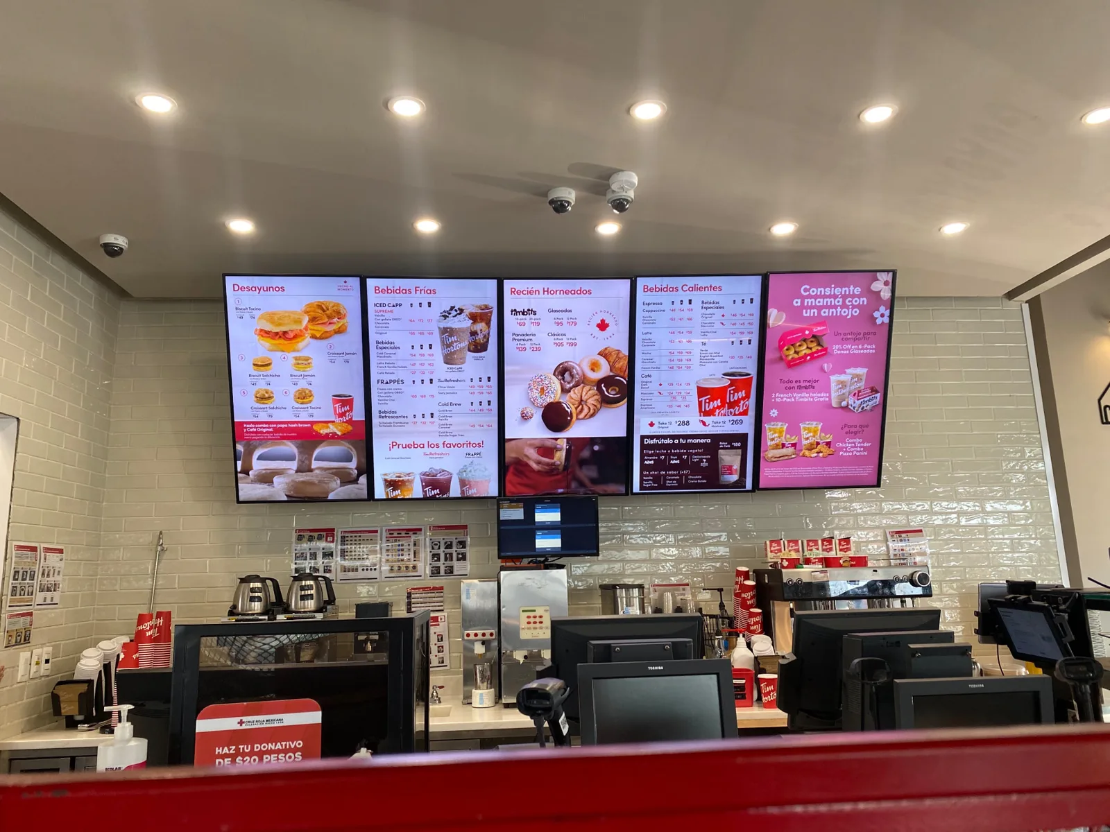 Row of five Tim Hortons digital menu screens above the service counter in Mexico